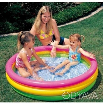
Яскравий і різнобарвний басейн для дітей, що складається з трьох надувних кілец. . фото 1